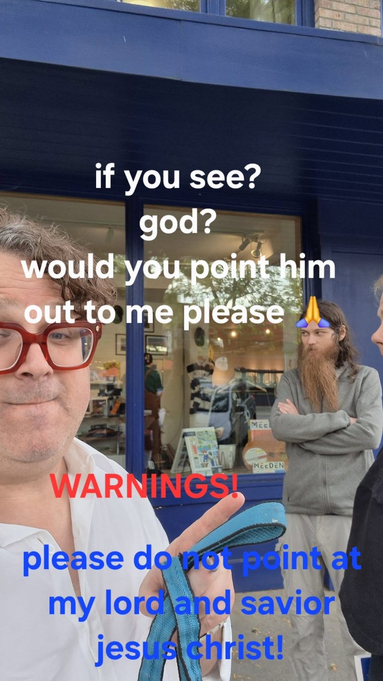 A man in a white shirt with a bearded man behind him