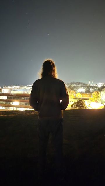 Backlit silhouette of a long-haired figure at sunset